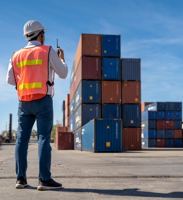 Operador supervisando contenedores de carga internacional